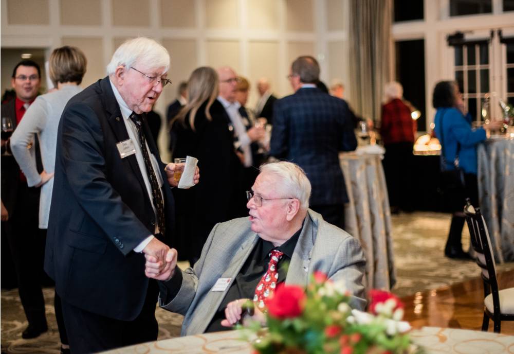 President Emeritus Don Lubbers shaking hands with a guest.